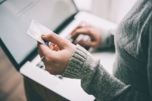 Woman paying with credit card and laptop