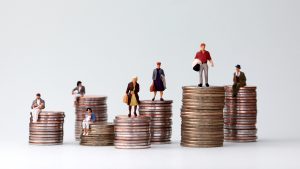 Model people standing on stacks of coins